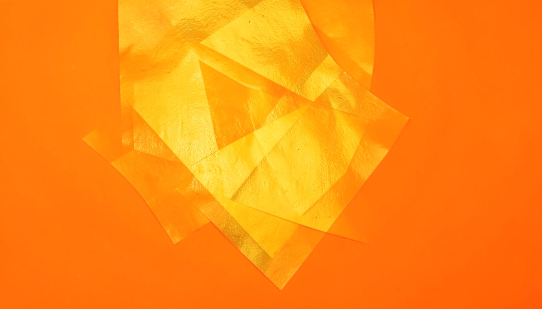 A warm golden-yellow abstract texture with subtle geometric patterns, studio photograph on a seamless backdrop